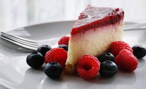 A Slice of Cheesecake with Strawberries and Blueberriese A Slice of Cheesecake with Strawberries and Blueberriese